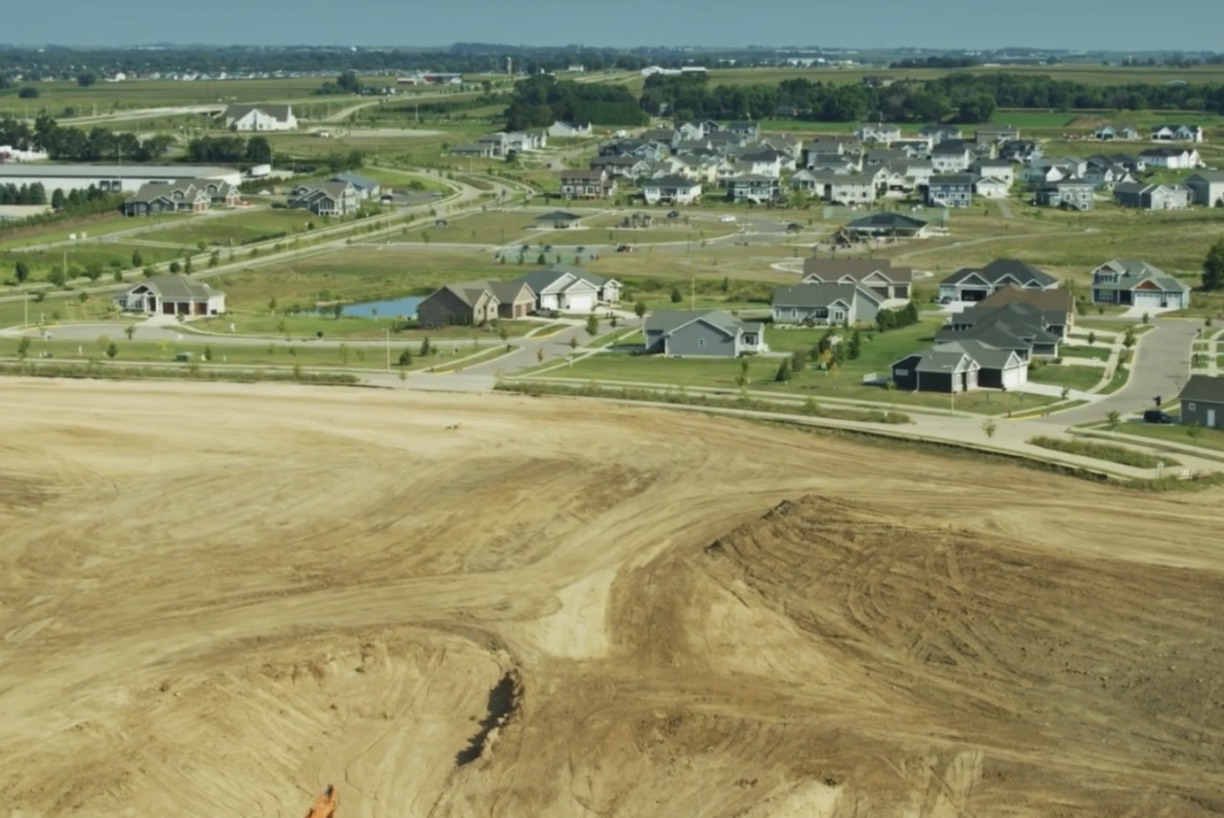 Professional land grading by HB Land Services — build-ready site pad near a residential development